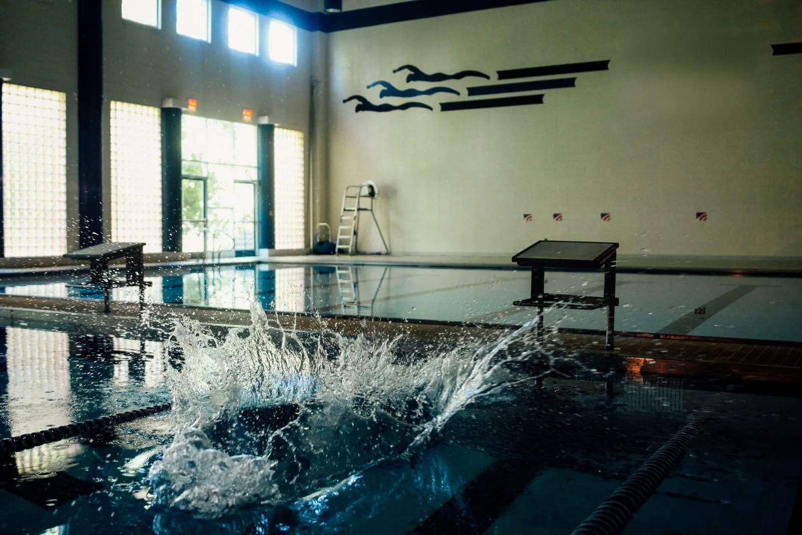 Dynamic splash in a serene indoor swimming pool environment.